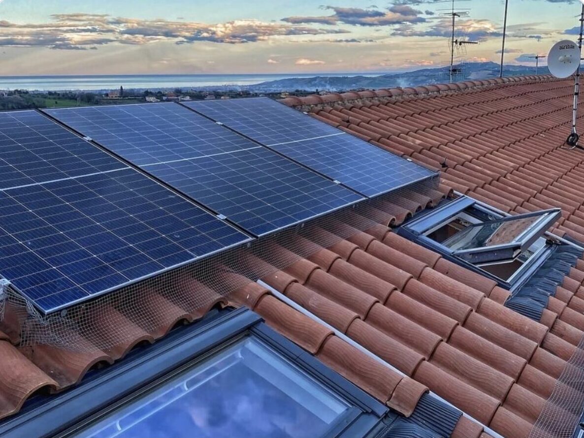 Finestre per tetti VELUX su tetto in coppi accanto all'impianto fotovoltaico, con vista mare